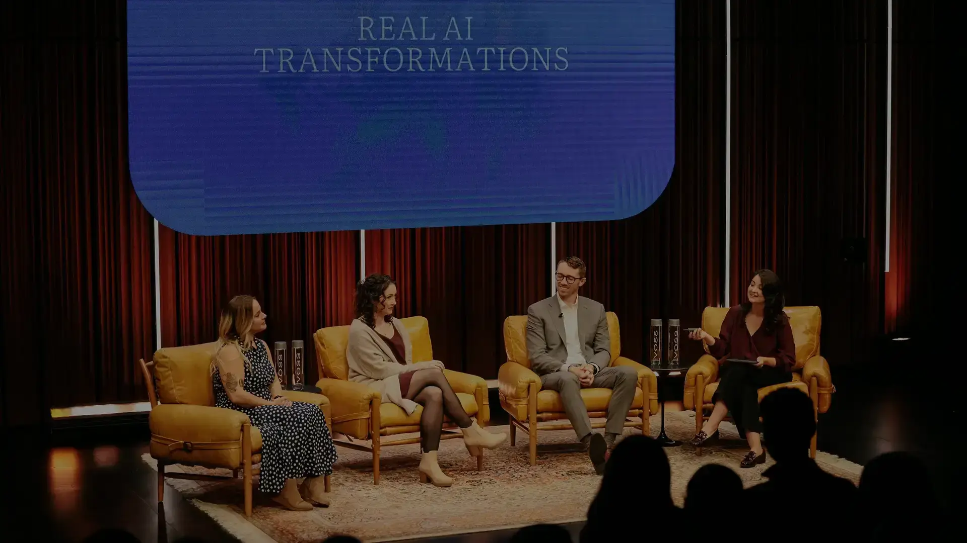 A group of people sat on chairs discussing AI in Customer Service.